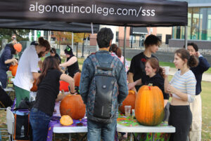 Students gather to participate in the pumpkin carving and Halloween festivities on the Front Lawn of Student Commons