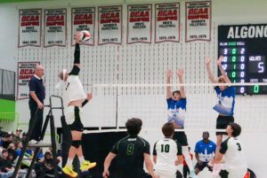 Player Mahmoud Abdelaziz is reaching for the volleyball to score a point for his team.