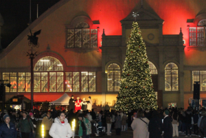 Crowds gather at Lansdowne Park for the Ottawa Christmas Market's grand tree lighting ceremony, set against the festive backdrop of the historic Aberdeen Pavilion.