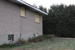 The fire started in the bedroom behind the top left window. The violent scorch marks are still slightly visible below.