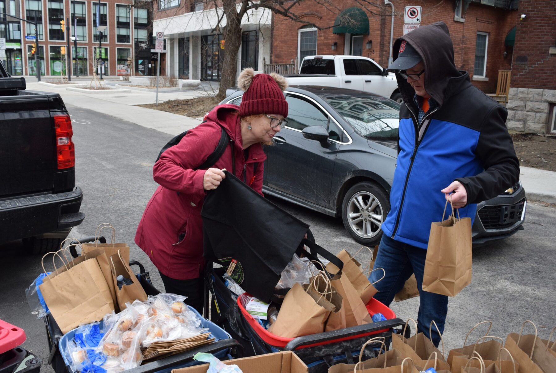Susan Lannigan (left) and Richard Blute (right) fill wagons with supplies for the street early afternoon on March 22, 2025.