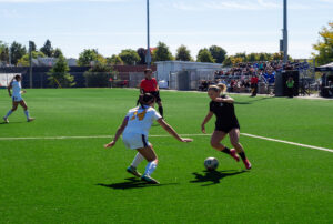 Mallory Armstrong, No.5 for the Wolves, moves the ball towards the goal at the Z building field against the Thunderwolves