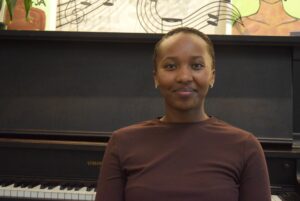Divine Ishimwe sits in front of piano in prayer room on Sept. 4  during a daily Christian prayer session