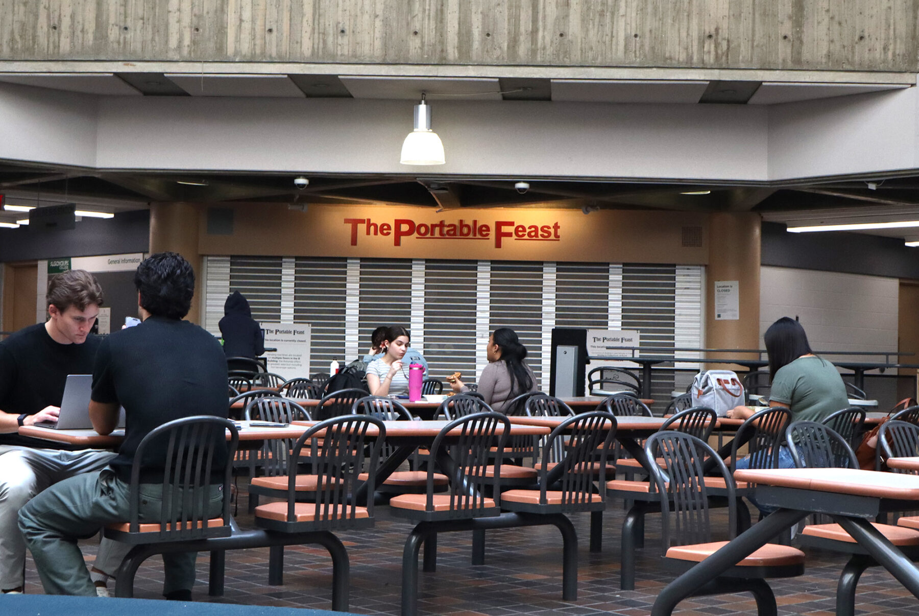 Students studying in the B-building cafeteria, in front of the Portable Feast.