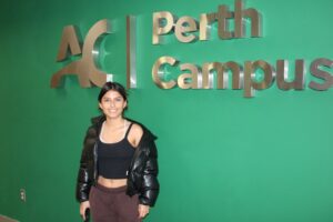 Student stood in front of Perth Campus sign.
