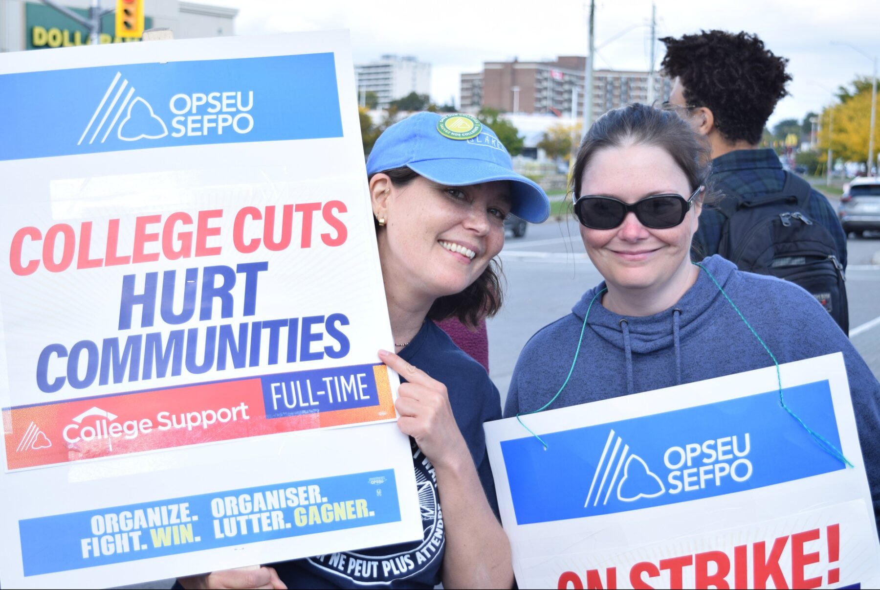 Erin McCue-Houlahan (left) and Sharon McCauley (right) proudly hold up their signs during the third week of the strike on Sept. 26, at Navaho Drive.