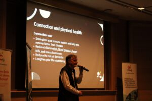 Fred May speaks about the link between social connection and physical health, emphasizing its role in reducing stress, lowering the risk of dementia, and improving total well-being.