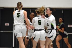 McDonald, Moore and the rest of the Wolves team celebrate victory over the Centennial Colts on Jan. 11, 2025