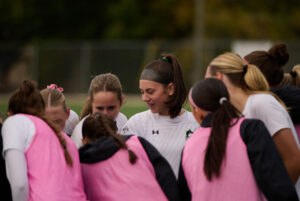 Wolves women's soccer team saying their cheer before the match begins at the Algonquin College sports field behind Z building