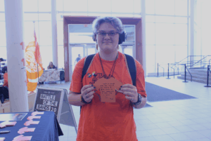 Siyh Chartrand holds his orange paper shirt with his action written on it Sept. 30 in the Student Commons.