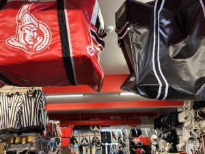 Senators hockey bag (left) hangs at Valiquette's Source For Sports with hockey gear (back)