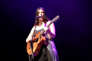 Emma Lamontagne on stage playing guitar and singing at Meridian Theatres at Centrepointe during Rock the Wild