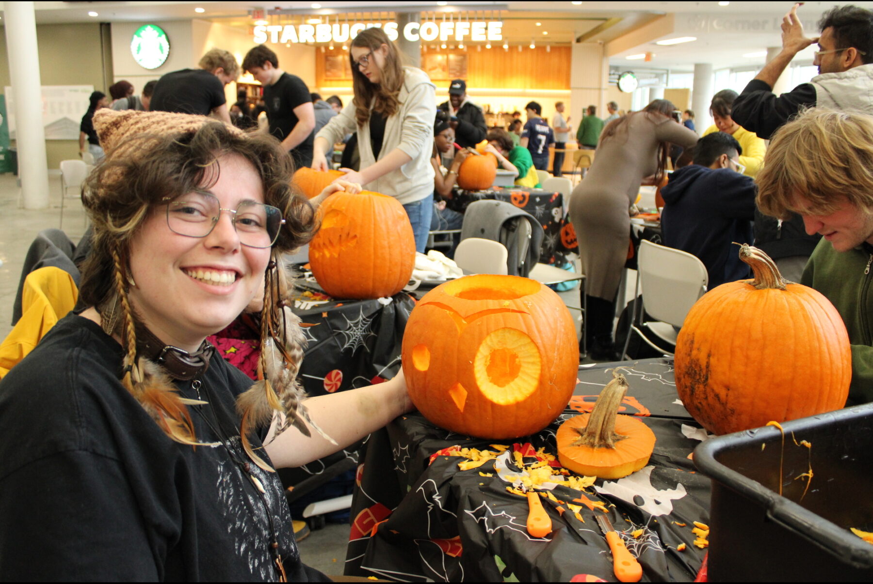 Sparrow Kaye shows off their almost finished pumpkin in the Student Commons on Oct. 30.