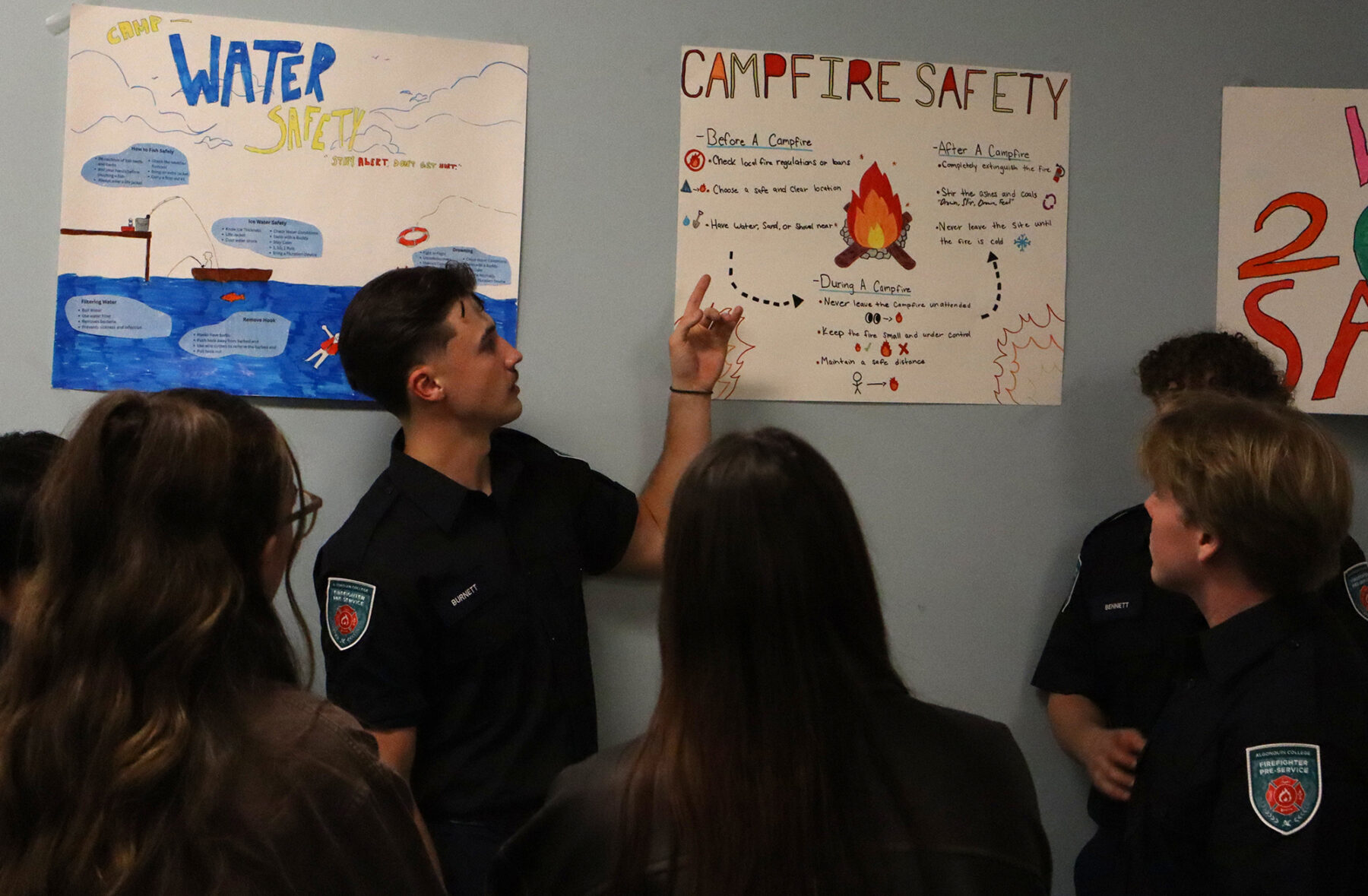 A student at the camp safety booth giving a presentation on campfire safety to attendees of the event.
