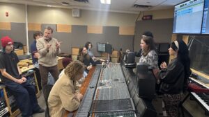 Music industry arts professor Jason Jaknunas teaching a class in the N building's music studio. Mills says they have some some plug-ins in the recording studio that have some AI elements to facilitate music production.