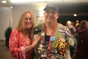 Michael Lalonde and Natasha Farinaccio smiling standing outside the theatre doors at Meridian Theatres at Centrepointe before the Rock the Wild concert, smiling and chatting