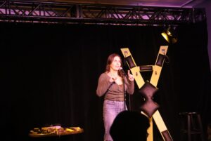 Sex educator Natalia of Kinks and Coffee introducing the show at the Sex-Positive Stand-Up Special