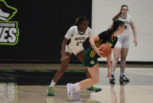 Cianah Miller (left), fifth-year guard, defends the Wolves' victory as the Lord's offensive pressure rises in the third quarter