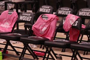 Pink Algonquin Wolves shirts draped over the players' chairs.