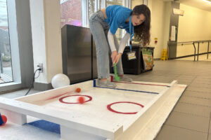 Keaghan Ruiter, a student hosting a booth in E-Building, playing the Happy Gilmore inspired game they created for the event.