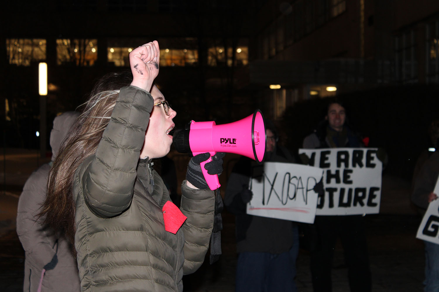 A student leads chants through a megaphone during an OSAP protest at the University of Ottawa, as demonstrators call for accessible education and increased financial support for post-secondary students.