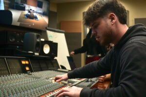 Students work on an audio mixing board during an after class session in Algonquin College’s Music Industry Arts program, which faces possible suspension despite strong graduate outcomes.
