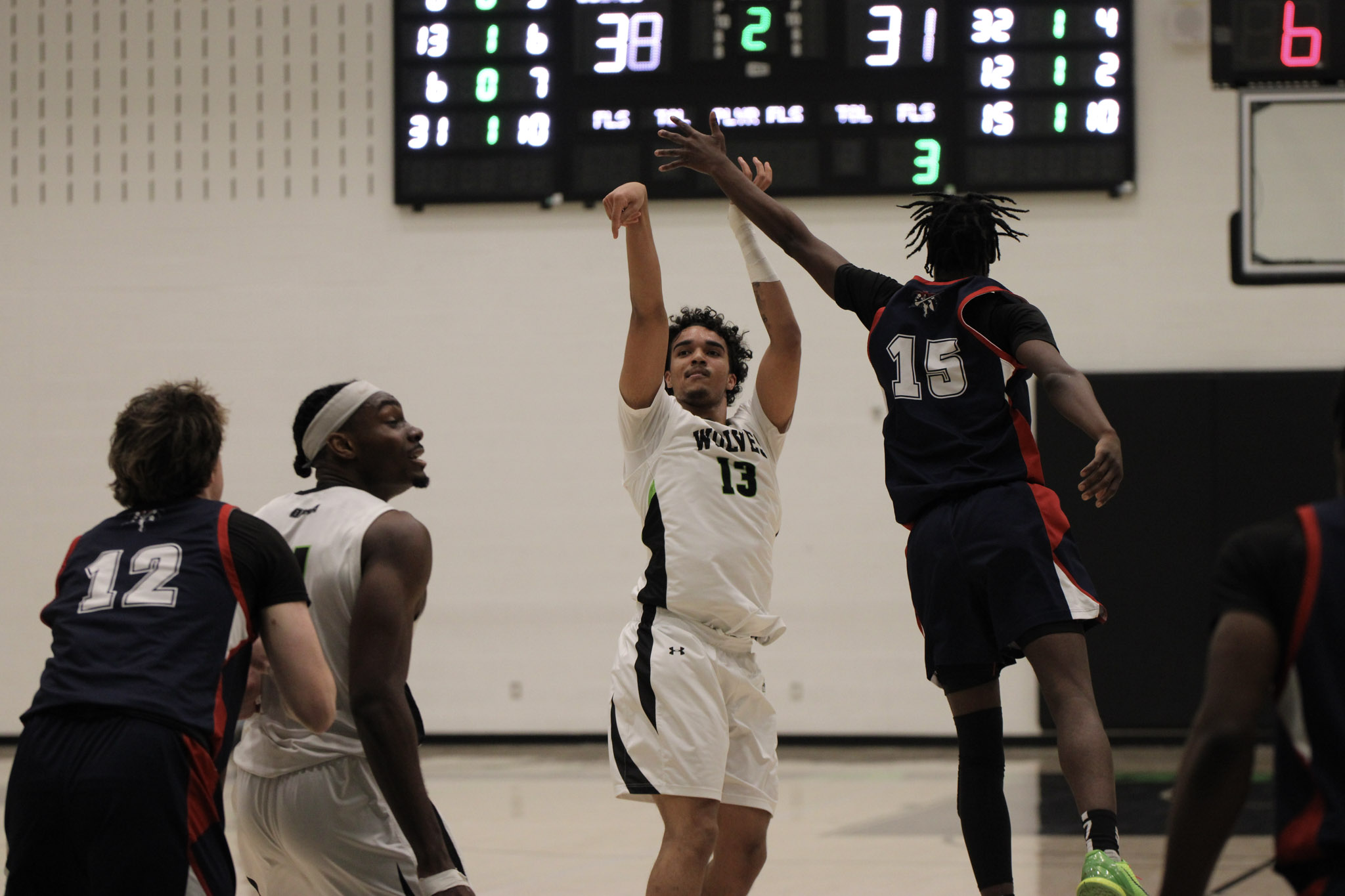 Forward Jahidi Webster attempts a three-pointer over Jalen Carter Jr of the Loyalist Lancers.