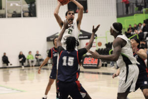 Forward Aydin Gilani is attempting a three-pointer over Jaylen Carter Jr of the Loyalists Lancers.