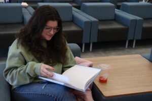 Alyssa Barrett looks through her notes while enjoying a Starbucks beverage in the Student Commons.