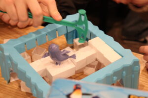 Attendees play the popular board game "Don&squot;t Break the Ice," where players have to smash the plastic ice cubes without making the toy penguin fall.