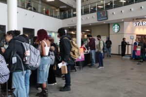Students look over the different booths set up around the space, stopping to check out the services available.