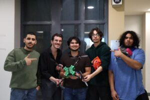 Algonquin Colleges robotics club posing proudly with their drone they built from scratch.