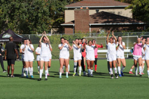 Womens soccer team applauding the crowd after a big win.