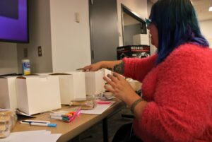 Hala Kassem sits at a table organizing the event's raffle.