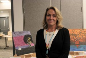 Wendy Gee stands in front of one of the artist tables at the Hope and Healing event.
