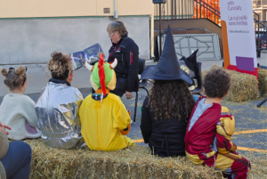 Janet Leak, of the Ottawa Public Library's Carlingwood branch, reads a Halloween story to children in costumes sitting on hay bales in the Churchill Seniors Centre parking lot on Sunday.